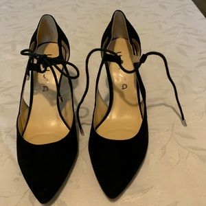 Black suede Unisa pumps with a tie string .